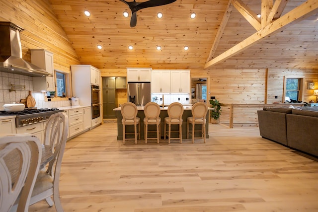 dining area with high vaulted ceiling, wooden walls, light wood-type flooring, wood ceiling, and beam ceiling