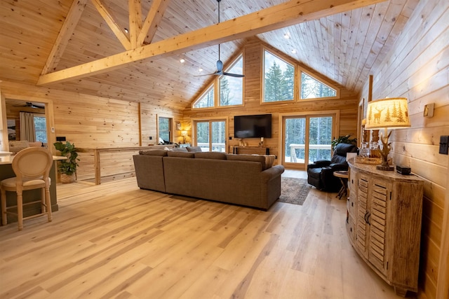 living room with wood ceiling, beam ceiling, wooden walls, high vaulted ceiling, and light hardwood / wood-style floors