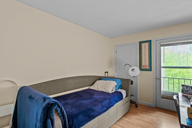 bedroom featuring a textured ceiling and light hardwood / wood-style floors