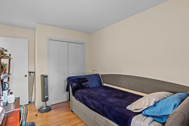 bedroom with light hardwood / wood-style floors and a closet