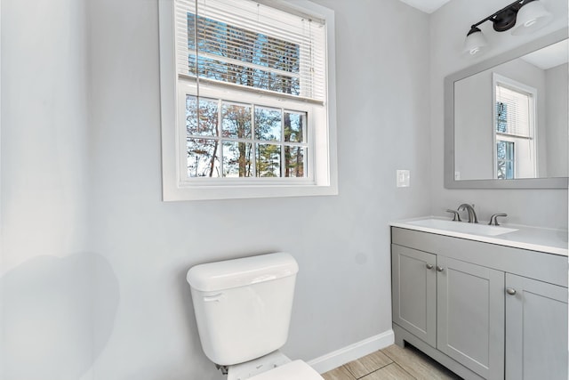 bathroom with plenty of natural light, toilet, and vanity