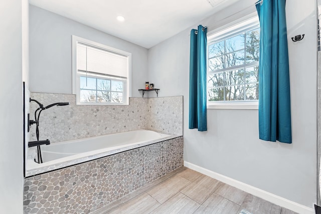 bathroom featuring a relaxing tiled tub