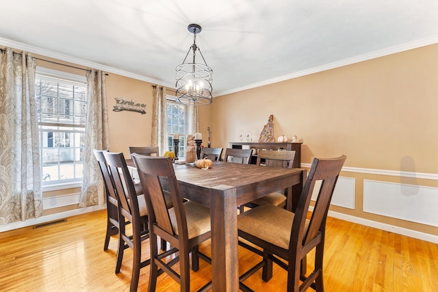 dining area with plenty of natural light, ornamental molding, and light wood-type flooring