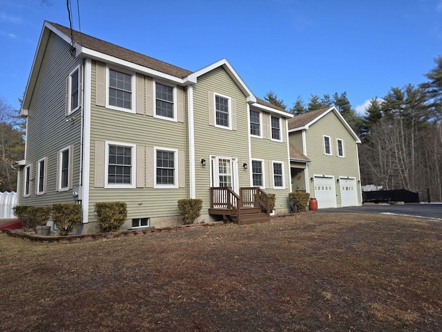 colonial inspired home featuring aphalt driveway and a garage