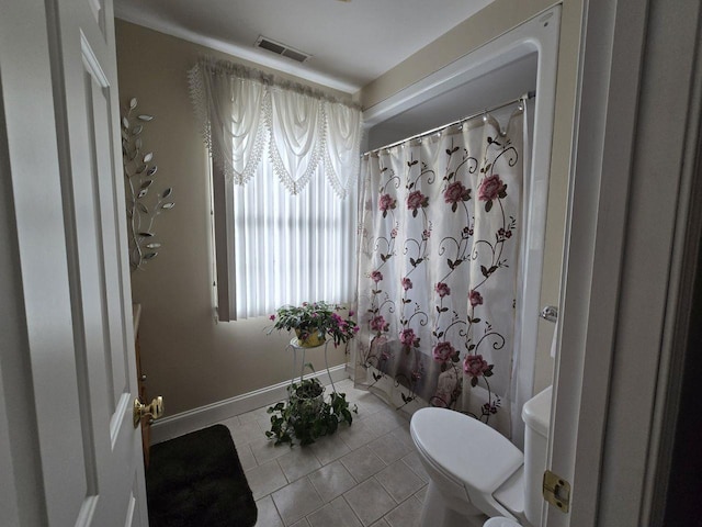 bathroom featuring shower / bath combination with curtain, tile patterned floors, and toilet