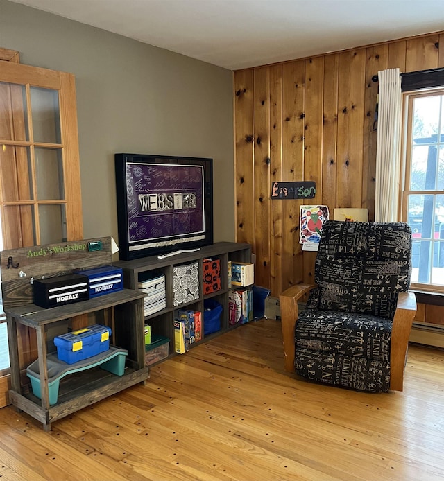 sitting room featuring light hardwood / wood-style floors and wood walls