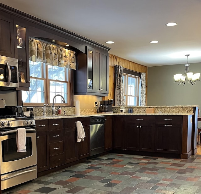 kitchen featuring sink, a chandelier, dark brown cabinets, pendant lighting, and stainless steel appliances