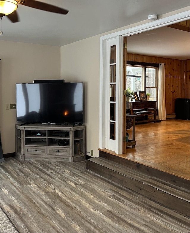 living room with hardwood / wood-style flooring, a baseboard heating unit, and ceiling fan