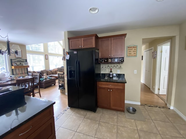 kitchen featuring a chandelier, light tile patterned floors, and black fridge with ice dispenser