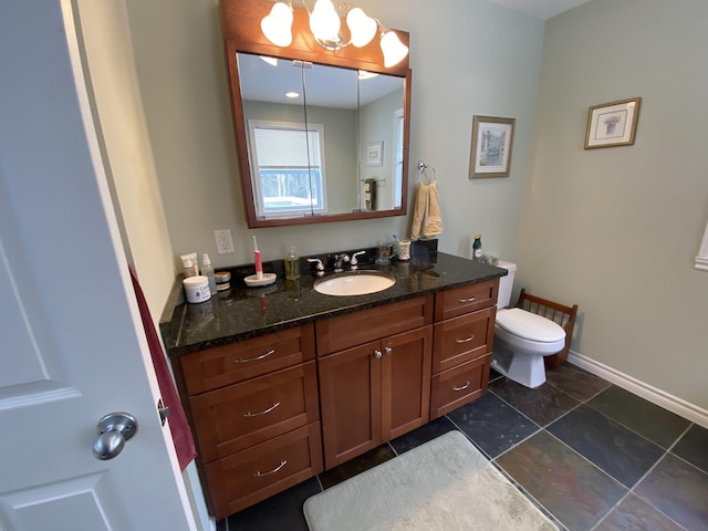 bathroom with vanity, an inviting chandelier, and toilet