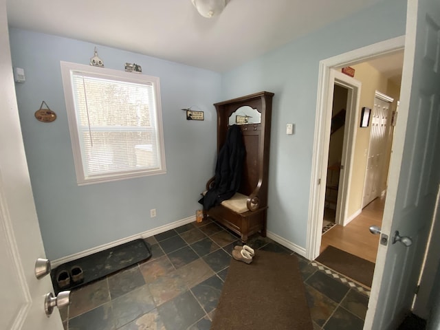 mudroom featuring stone finish floor and baseboards