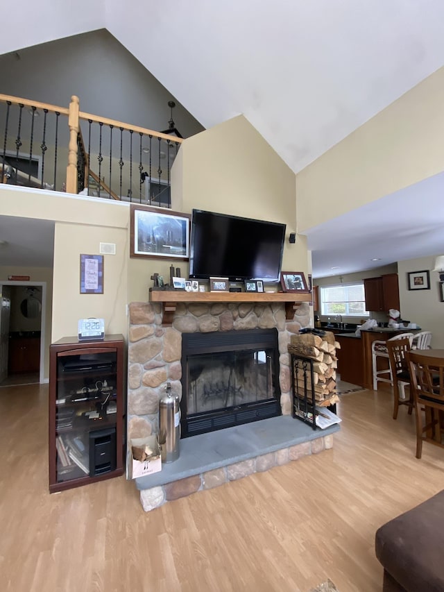 living room featuring hardwood / wood-style floors, vaulted ceiling, and a fireplace