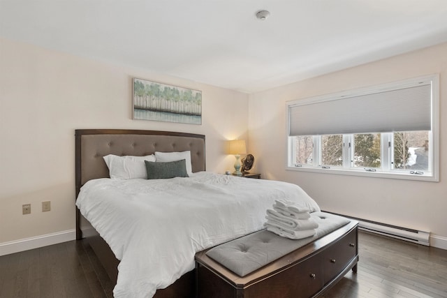 bedroom with a baseboard heating unit and dark hardwood / wood-style floors