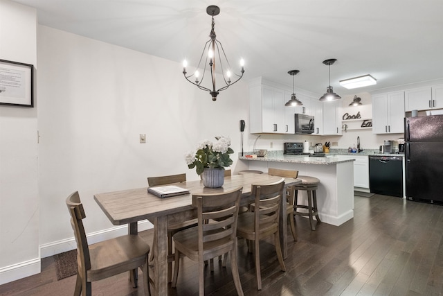 dining space featuring dark wood-type flooring, sink, and a notable chandelier