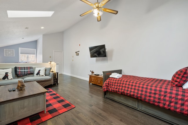 bedroom featuring dark hardwood / wood-style floors, ceiling fan, and vaulted ceiling with skylight