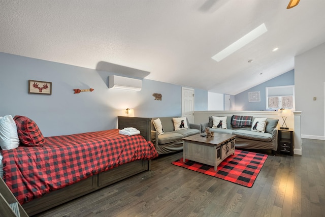 bedroom with dark hardwood / wood-style floors, lofted ceiling with skylight, and an AC wall unit