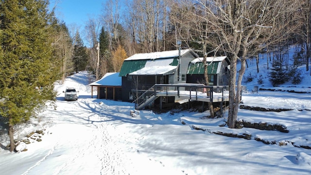 snow covered rear of property with a wooden deck