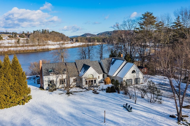 snowy aerial view with a water and mountain view