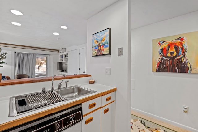 kitchen featuring light colored carpet, dishwasher, and white cabinets