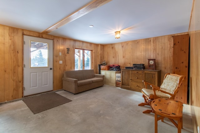 interior space featuring beamed ceiling and wooden walls