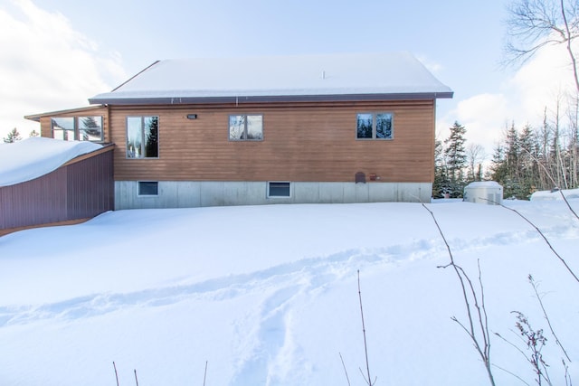 view of snow covered back of property