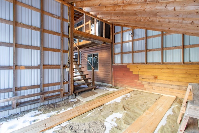 miscellaneous room featuring vaulted ceiling and wooden walls