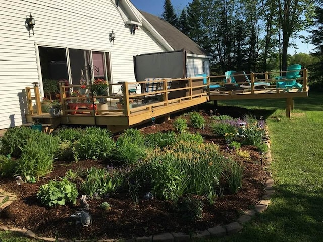 back of house with a deck and a lawn