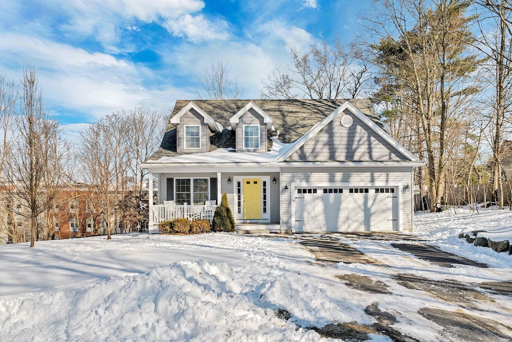 cape cod home with a garage and a porch