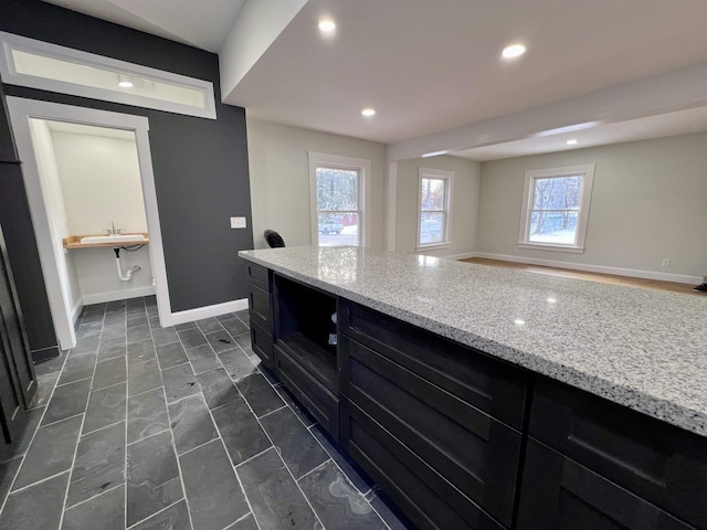 kitchen featuring light stone counters and a wealth of natural light