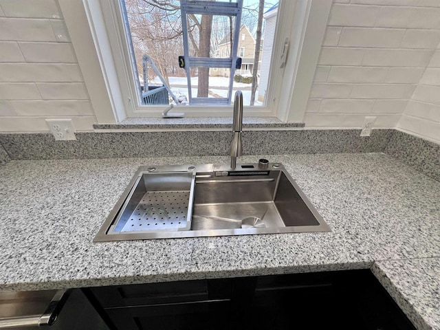 details featuring light stone counters and sink