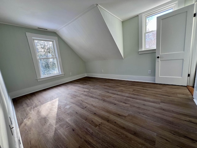 bonus room with plenty of natural light, dark hardwood / wood-style floors, and vaulted ceiling