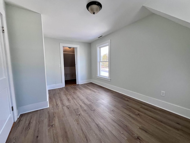 unfurnished bedroom with a spacious closet, light wood-type flooring, and a closet