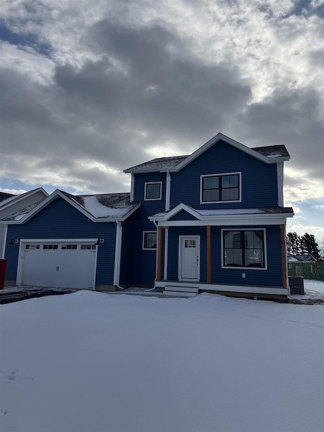 front of property with central AC unit and a garage