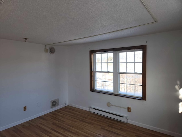 unfurnished room featuring baseboard heating, dark wood-type flooring, and a textured ceiling