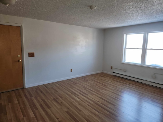 unfurnished room with a baseboard radiator, dark hardwood / wood-style floors, and a textured ceiling