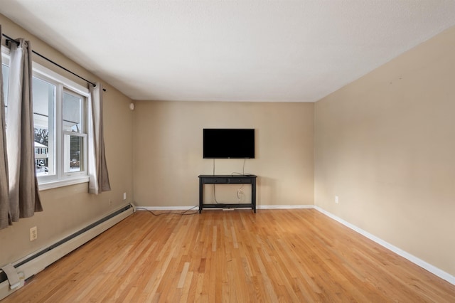 unfurnished living room featuring a baseboard radiator and light hardwood / wood-style flooring