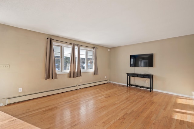 unfurnished living room featuring a baseboard heating unit and light hardwood / wood-style flooring