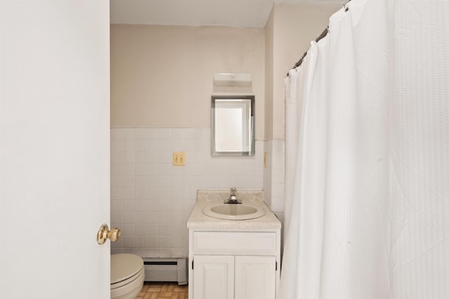 bathroom featuring a baseboard radiator, vanity, toilet, and tile walls