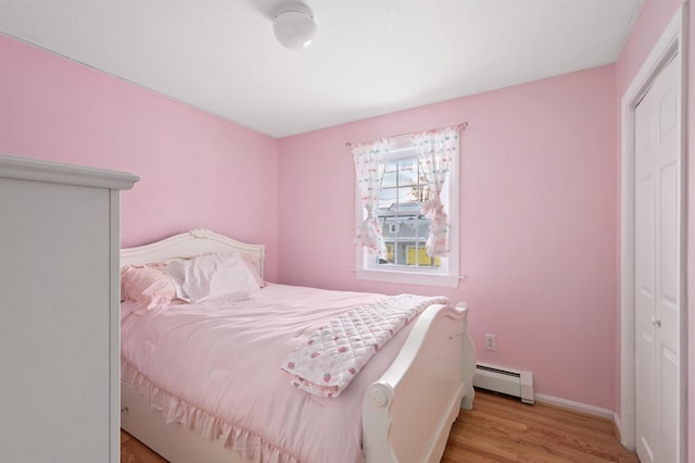 bedroom featuring a baseboard radiator, a closet, and light wood-type flooring