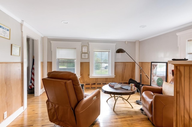 living area featuring ornamental molding, light hardwood / wood-style flooring, and wood walls