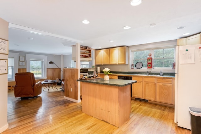 kitchen with sink, white fridge, a kitchen island, light brown cabinetry, and light wood-type flooring