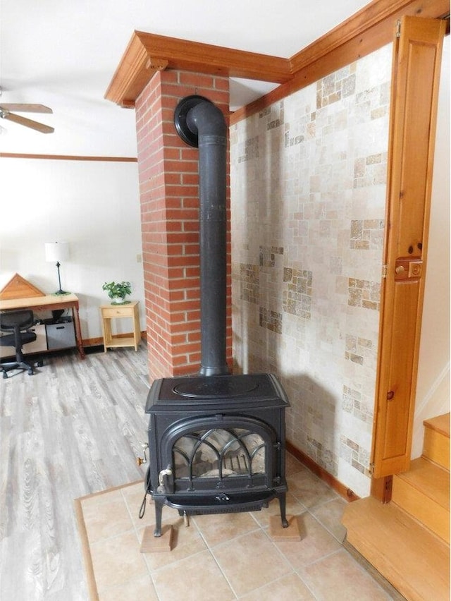 room details featuring hardwood / wood-style flooring, ceiling fan, and a wood stove