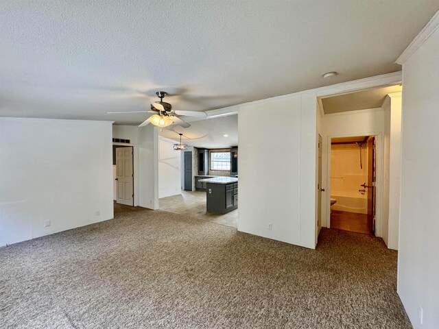 unfurnished living room with light carpet, a textured ceiling, crown molding, and ceiling fan