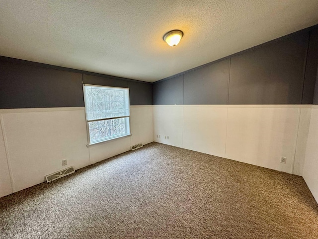 carpeted empty room featuring ornamental molding and a textured ceiling