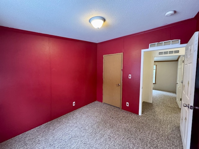 carpeted spare room with a textured ceiling