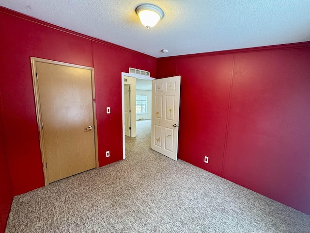 carpeted spare room with a textured ceiling