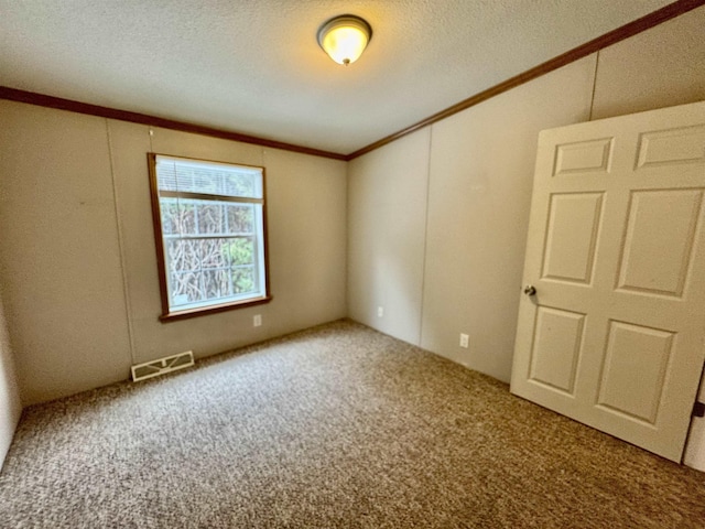 unfurnished room featuring ornamental molding, carpet, and a textured ceiling