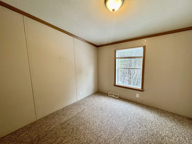 unfurnished room featuring ornamental molding, a textured ceiling, and carpet flooring