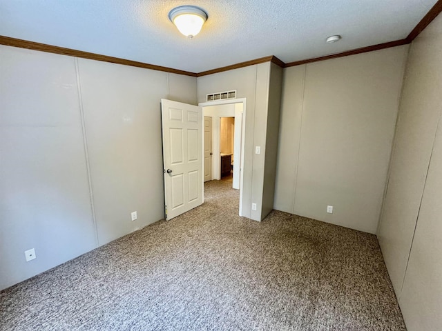 empty room featuring crown molding, a textured ceiling, and carpet