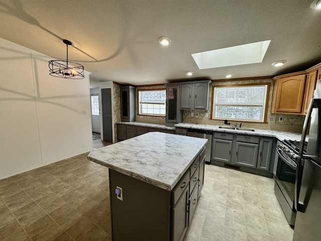 kitchen featuring stainless steel appliances, a center island, hanging light fixtures, a healthy amount of sunlight, and decorative backsplash